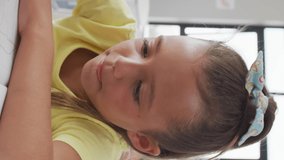 Video of happy caucasian girl sitting at school desk and learning. primary school education, knowledge and learning concept.
