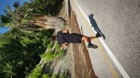 Athlete running outdoors. Vertical video. Man in black sportswear jogging on road. Young fit male triathlete training in mountains, preparing for run race marathon. Sport concept. Fitness workout