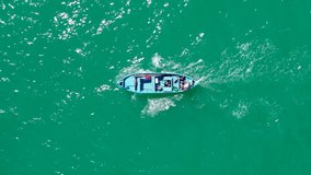 Top down view of wooden fishing boat and fisherman, sailing.