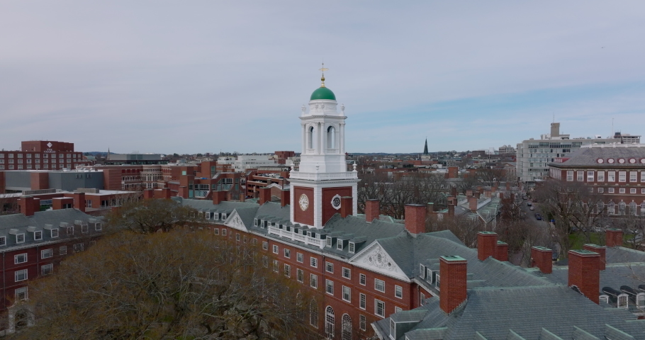 Fly above Harvard University campus complex. Tight flight around white tower at Eliot House. Boston, USA