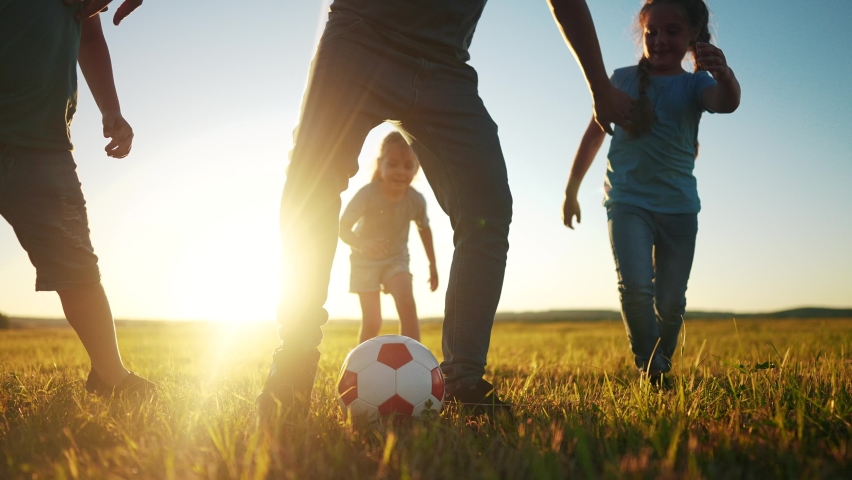 happy family playing a soccer in the park. group of children in nature playing ball with father silhouette park. happy family kid dream concept. funny kids playing ball on the grass in summer sunlight Royalty-Free Stock Footage #1091918787