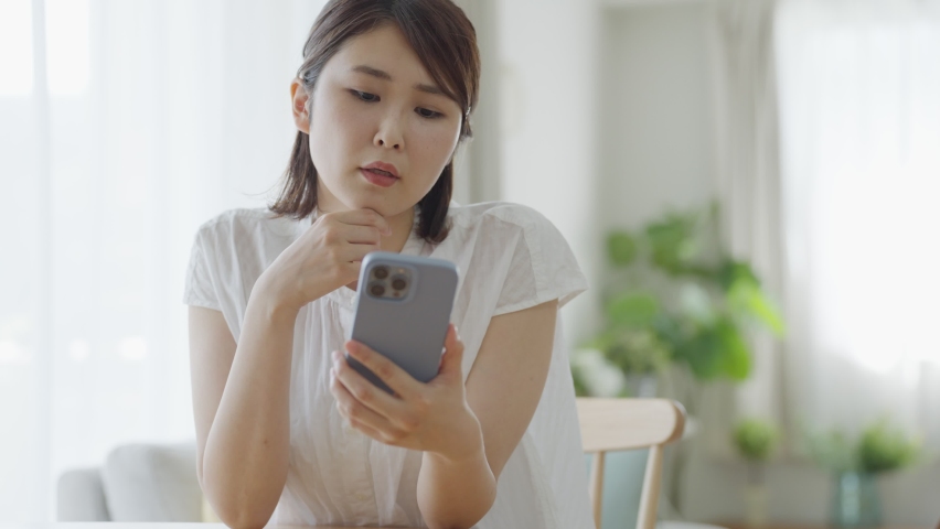 Asian woman looking at a smartphone Royalty-Free Stock Footage #1091919737