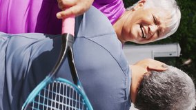 Video of happy biracial senior couple embracing after after match on tennis court. active retirement lifestyle, senior relationship and tennis training concept. - Powered by Shutterstock - Get 15% off with code: PIKWIZARD15