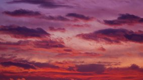 Red purple sunset sky clouds time lapse motion 4K footage background. Sunset sun light sky pass dark cloud fast move fly rolling weather time lapse background. Cloudscape 4K nature landscape day night