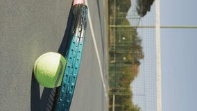 Video of tennis ball and racket lying on tennis court. professional tennis training, sport and competition concept.
