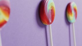 Video of rows multicoloured lollipops on blue background. colourful fun food, candy, snacks and sweets concept.