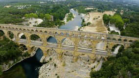 Aerial bird view footage Pont du Gard is ancient Roman aqueduct that crosses Gardon River. Pont du Gard aqueduct bridge built by the Romans in the first century. UNESCO's list of World Heritage Sites.