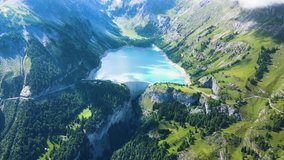 Water dam and reservoir lake aerial drone footage in green Swiss Alps mountains generating hydroelectricity. Low CO2 footprint, decarbonize, renewable energy, sustainable development. 4K 60fps video.