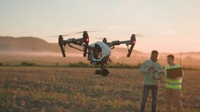 African and asian farm engineers using laptop digital tablet controlling application for automated flying drone. Farming activity, increasing productivity. Teamwork. Field landscape. - Powered by Shutterstock - Get 15% off with code: PIKWIZARD15