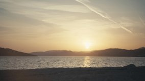 Time-lapse video of a girl jogging by the sea at sunset. Active lifestyle workout at sunrise in beautiful ocean scenery. High quality 4k footage