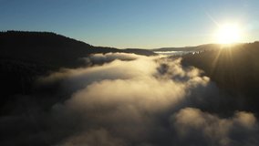 Aerial view of a misty lake. Dawn dark lights during sunrise, cold weather. Flying over clouds in the mountains - Powered by Shutterstock - Get 15% off with code: PIKWIZARD15