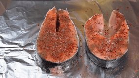 Chef adding spices and olive oil on raw salmon steak before baking. Raw salmon Fillet or red fish steak. Seasoning salmon steak. High quality FullHD footage