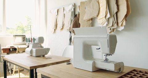 Tailor's workplace with modern sewing machine and patterns in atelier. Professional sewing machine on the background of designer studio. Workplace of tailor and sewing business concept 
