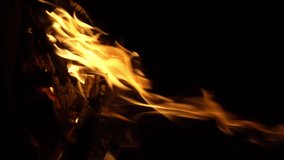 Fire flame isolated black isolated background Beautiful orange. Flame border . Sparks from campfire over dark night background. Christmas background, Slow motion. Bonfire is burning, vertical video
