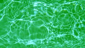 Defocus blurred transparent green water colored clear calm water surface texture with splashes and bubbles. Trendy abstract nature background. Water waves in sunlight. Close up green water background.