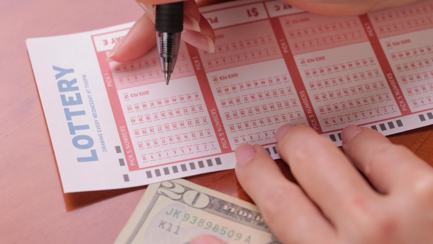 Close-up shot of a pen filling in numbers on a lottery ticket. Royalty-Free Stock Footage #1091943611
