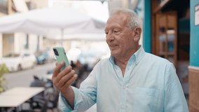 Senior grey-haired man smiling confident having video call at street