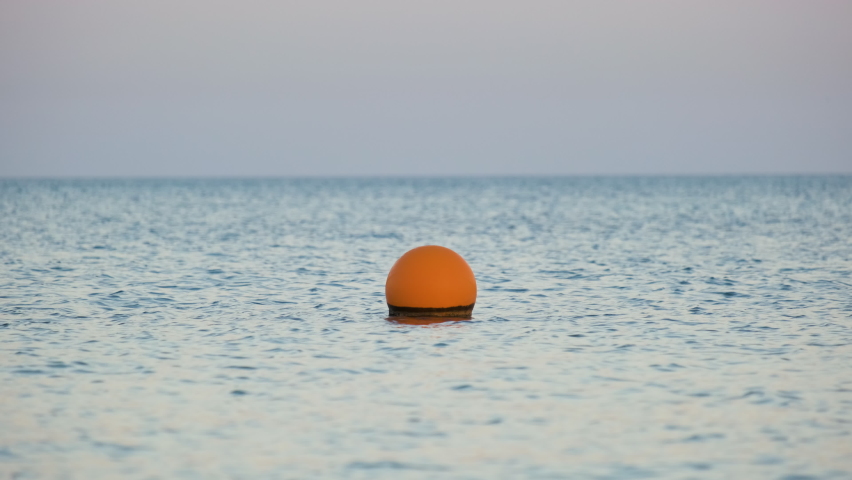 Yellow buoy floating on sea surface as marker for swimming restriction in deep water at tropical resort. Human life safety concept Royalty-Free Stock Footage #1091947919