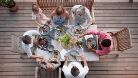 Top view of 3 generations family eating at barbecue party dinner on patio, people sitting at table on patio with grill. - Powered by Shutterstock - Get 15% off with code: PIKWIZARD15