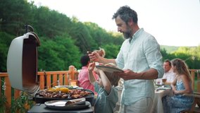 Man grilling ribs and vegetable on grill during family summer garden party, close-up - Powered by Shutterstock - Get 15% off with code: PIKWIZARD15