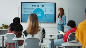Young High school teacher giving marketing lesson to students in classroom - Powered by Shutterstock - Get 15% off with code: PIKWIZARD15