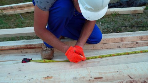 Construction worker builds a house. Caucasian Contractor and the Wooden House Frame.Energy efficient frame house. New framing construction of a house. Construction crew working,  commercial apartment