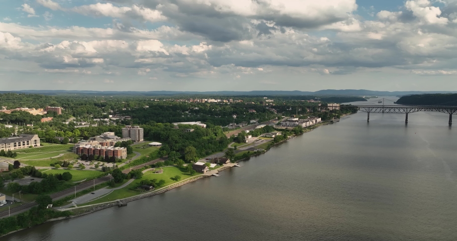 Summer afternoon aerial drone video of the east side of the Hudson River, Poughkeepsie, NY, walking bridge and Mid-Hudson Bridge of the Hudson River..  Royalty-Free Stock Footage #1091960567