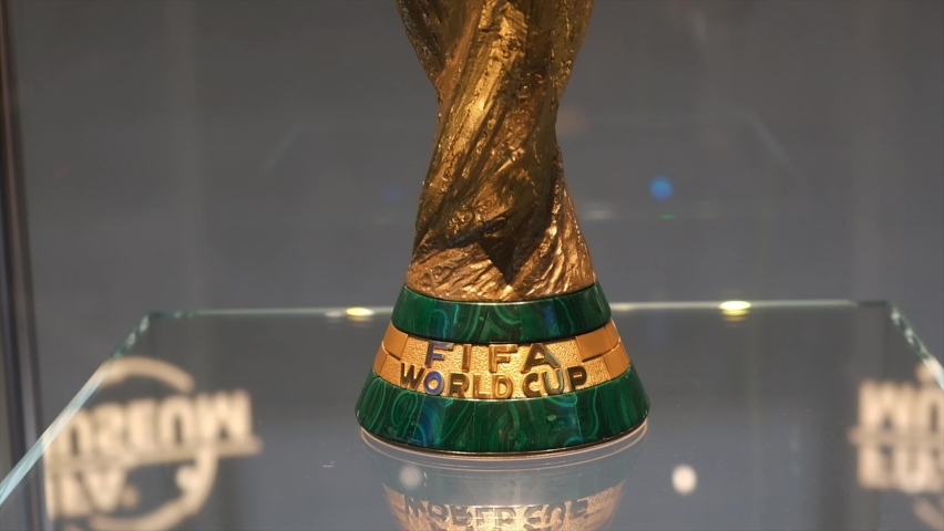 "Zürich, Switzerland- Circa June, 2022: A handheld roll up footage with noise effect added changeable light of World Cup trophy at Fifa Museum."