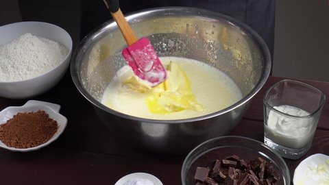 Closeup view of male hands preparing dough mixing flour with other ingredients. Add butter in bowl