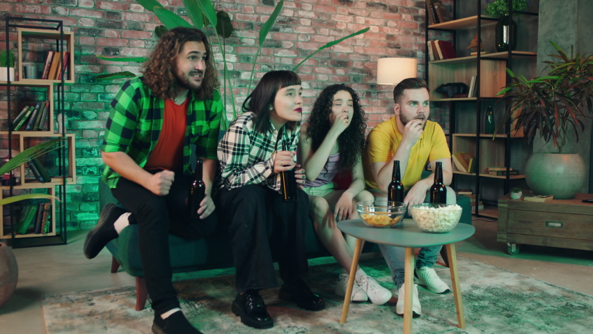 Charismatic and good looking group of friends meeting at home to watching on tv football match they getting excited and clapping hands when favourite team getting the victory | Shutterstock HD Video #1091976079