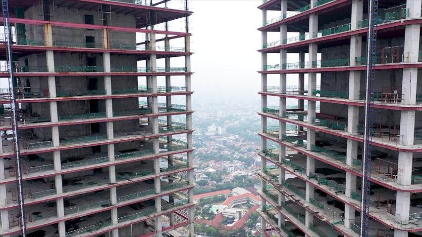 Aerial shot of modern glass skyscraper under construction in Jakarta City Royalty-Free Stock Footage #1091979255