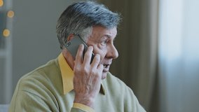 Caucasian old grey-haired man grandfather at home talking on mobile phone remote conversation distant consultation with doctor answering call emotionally speaking with smartphone connection service - Powered by Shutterstock - Get 15% off with code: PIKWIZARD15