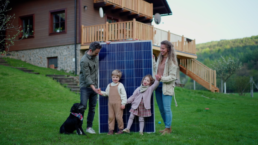 Happy family near their house with solar panels. Alternative energy source Royalty-Free Stock Footage #1091991497