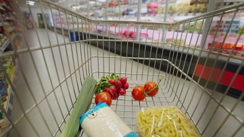 Woman with shopping cart or trolley buying food at grocery store or supermarket, inside view from trolley, videoclip de stoc