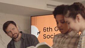 Chest up slowmo of mid adult male teacher listening to multiethnic school girls report on Social Studies - Powered by Shutterstock - Get 15% off with code: PIKWIZARD15