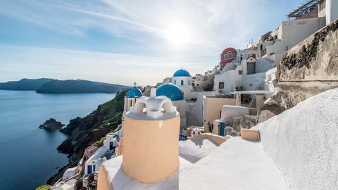 Blue domed churches and white-washed houses in the village of Oia on the edge of the volcanic caldera on the island of Santorini in Greece.