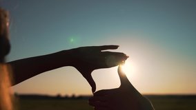 Business strategy. Girl folded her hands in frame at sunset. Silhouette of girl in natural park. Fingers at sunset. Work planning. Girl in field folded her hands into frame. Business planning concept. - Powered by Shutterstock - Get 15% off with code: PIKWIZARD15