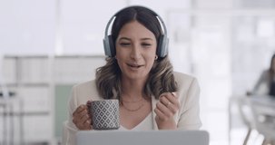 Young female call center agent advising a client on headphones during an online video call. Happy advisor consulting and talking while in a webinar, conference, meeting or on the customer care line