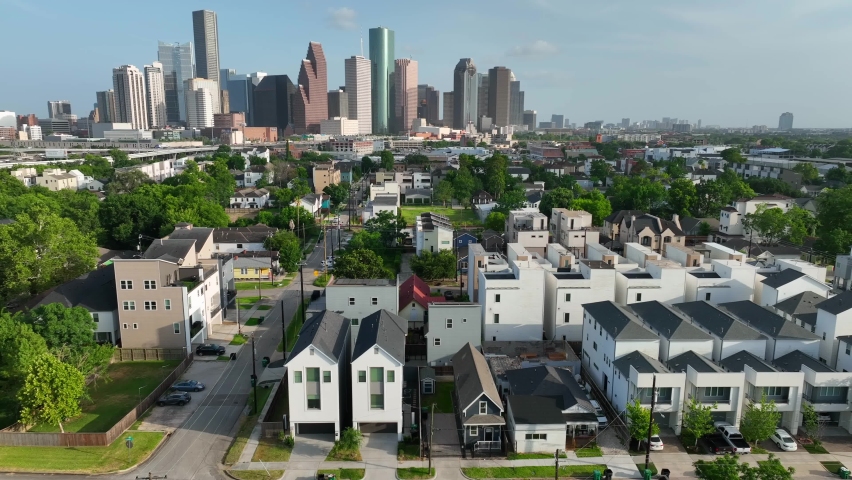Modern new housing residential development homes. Neighborhood with Houston Texas skyline in distance. Aerial establishing truck shot. Royalty-Free Stock Footage #1092020743