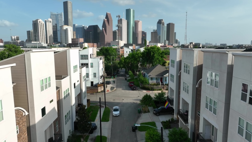 Contemporary residential building in the city. American skyline in distance. Multistory apartment building. USA lifestyle living in downtown metropolis. Rising aerial reveal.