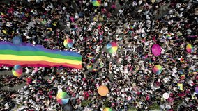 cenital drone shot of a crowd waving the gay pride flag at the pride parade in mexico city - Powered by Shutterstock - Get 15% off with code: PIKWIZARD15