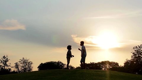 Children playing at sunset. Kids run on the lawns of the evening.