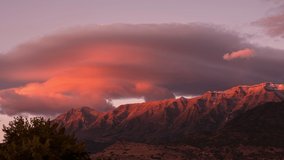 Lenticular clouds during colorful sunset over Timpanogos Mountain in Utah moving in time lapse. - Powered by Shutterstock - Get 15% off with code: PIKWIZARD15