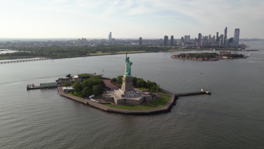 Lady Liberty statue and island, in sunny New York, USA - rising, tilt Aerial Royalty-Free Stock Footage #1092039359