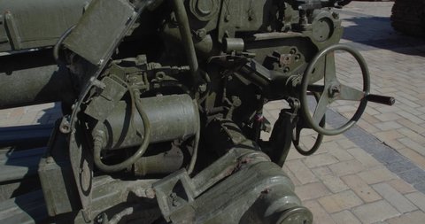Tracking shot close up of Russian howitzer destroyed by Ukrainian artillery shelling, exhibited on city street for demonstration. Detail of rusty burnt military weapon D-30