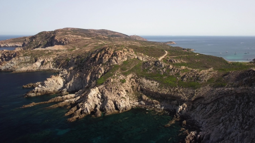 Aerial view panning along La Revellata, a rocky promontory on the west coast of Corsica near Calvi on a clear sunny morning Royalty-Free Stock Footage #1092044047