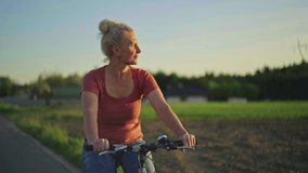 A 50-year-old woman rides a bicycle in the park. A slow motion video of a happy elderly man playing sports and an active lifestyle riding a bicycle.