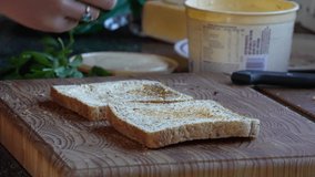 A 4K Slow motion Video of Low GI Bread being used to make a healthy lunch with butter and Mayonnaise with Baby spinach as a healthy living snack