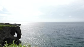 OKINAWA, JAPAN - AUG 2021 : View of sea and Cape Manzamo located near Onna son village in the Kunigami District. Wide view, real time shot in daytime. Summer holiday, vacation and resort concept video