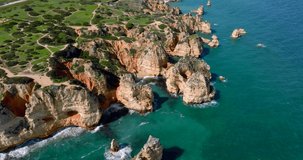 Drone shot from the Algarve region in Portugal, the drone is moving closer to the coast on a sunny day